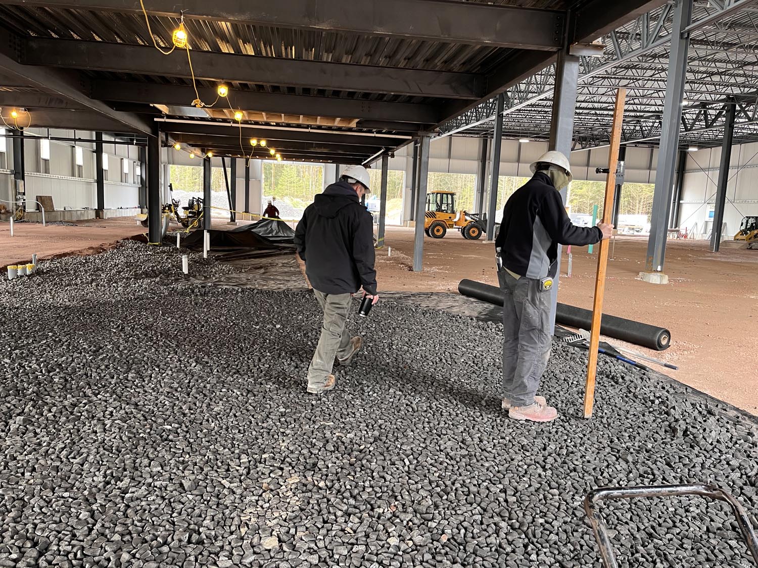 Two men inspecting foamed glass aggregate application